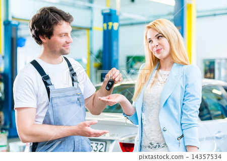 Workshop mechanic handing car to customer 14357534