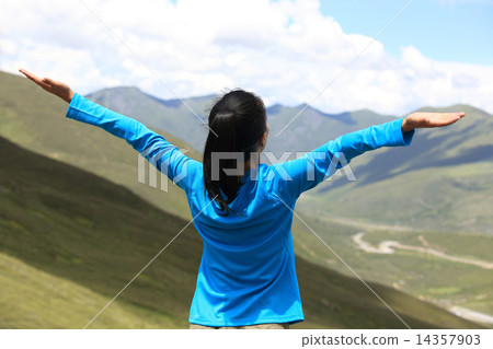 cheering hiking woman enjoy the beautiful view at mountain peak in tibet,china cheering hiking woman enjoy the beautiful view at mountain peak in tibet,china 14357903