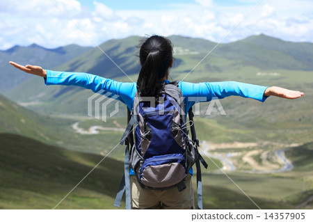 cheering hiking woman enjoy the beautiful view at mountain peak in tibet,china cheering hiking woman enjoy the beautiful view at mountain peak in tibet,china 14357905