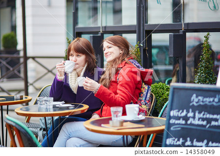Two cheerful young girls in a Parisian street cafe 14358049