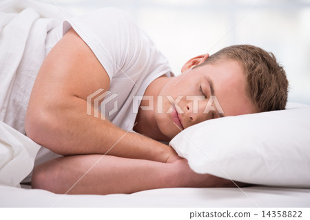 Young man sleeping under a blanket Young man sleeping under a blanket 14358822