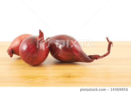Red onions composition over a wooden table 14369958
