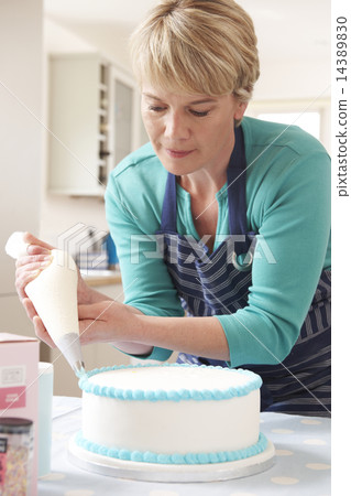 Woman Icing Birthday Cake In Kitchen At Home Woman Icing Birthday Cake In Kitchen At Home 14389830