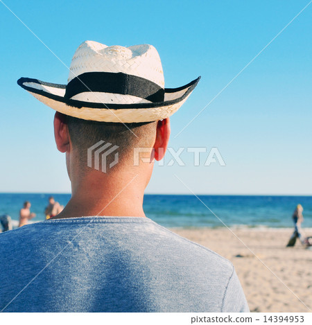 young man with a straw hat on the beach young man with a straw hat on the beach 14394953