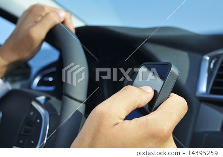 man using a smartphone while driving a car man using a smartphone while driving a car 14395259