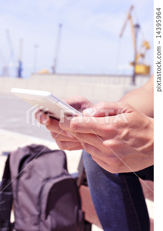 young man using a tablet or an e-book outdoors 14395964