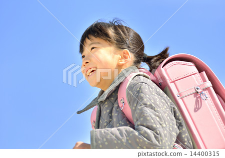 Girls running in the blue sky (school bags, winter) 14400315