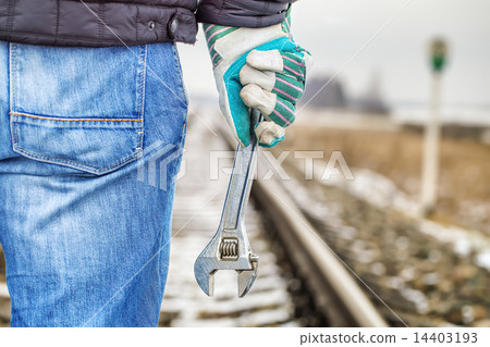 Man with adjustable wrench on the railroad  14403193