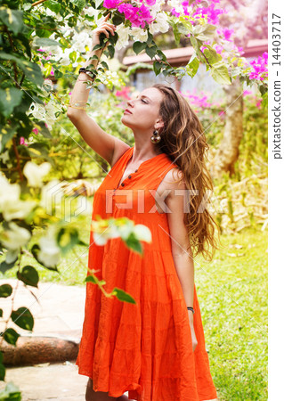 Pretty woman in park with flowers Pretty woman in park with flowers 14403717