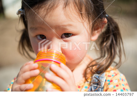 A girl drinking water in a water bottle 14403797