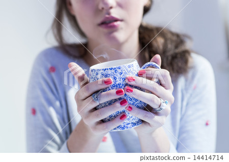 Young woman holding decorative cup of tea Young woman holding decorative cup of tea 14414714