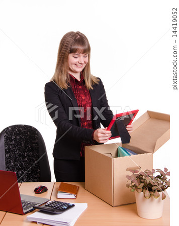 Girl puts a photo frame on desktop from box office 14419052