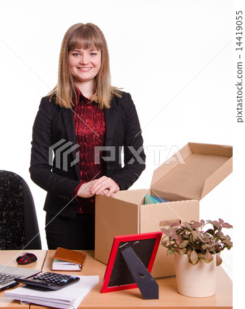 Girl standing behind an office desk with a big box 14419055
