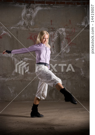 Beautiful hip hop girl dancing over grey brick wall 14419807