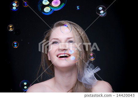 Closeup portrait of blond girl with soap bubbles on black 14420043