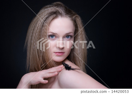Close up portrait of blond girl with feather on black Close up portrait of blond girl with feather on black 14420053