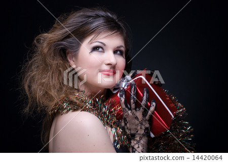 Closeup portrait of girl with red lips, tinsel and present on bl Closeup portrait of girl with red lips, tinsel and present on bl 14420064