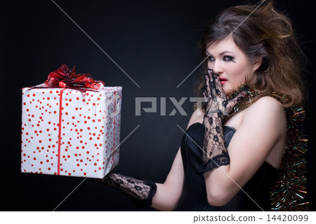 Closeup portrait of girl with red lips, tinsel and present on bl Closeup portrait of girl with red lips, tinsel and present on bl 14420099