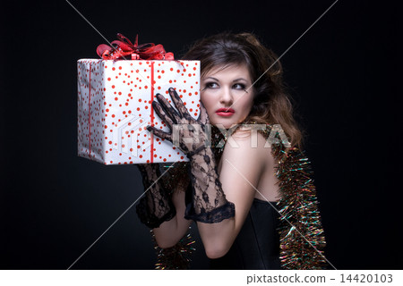 Closeup portrait of girl with red lips, tinsel and present on bl Closeup portrait of girl with red lips, tinsel and present on bl 14420103