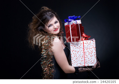 Closeup portrait of girl with red lips, tinsel and present on bl Closeup portrait of girl with red lips, tinsel and present on bl 14420105