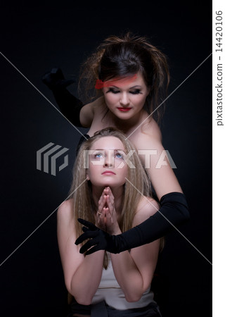 Closeup portrait of two girls: good & evil 14420106