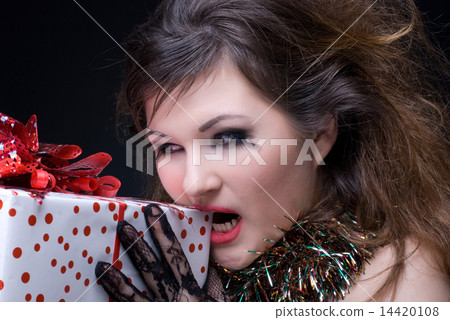 Closeup portrait of girl with red lips, tinsel and present on bl Closeup portrait of girl with red lips, tinsel and present on bl 14420108