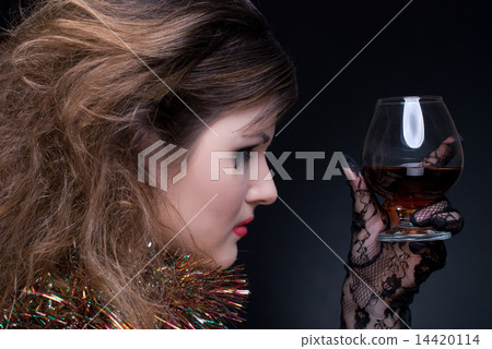 Closeup portrait of girl with red lips, tinsel and wineglass on 14420114