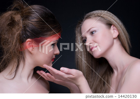 Closeup portrait of two girls: good & evil Closeup portrait of two girls: good & evil 14420130