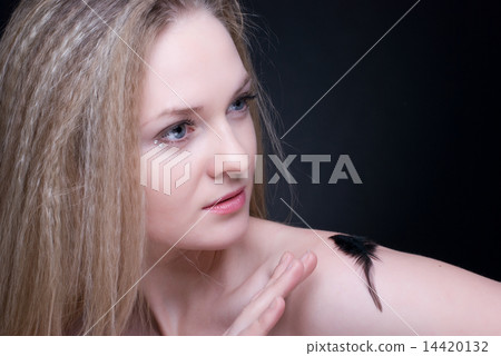 Close up portrait of blond girl with feather on black Close up portrait of blond girl with feather on black 14420132