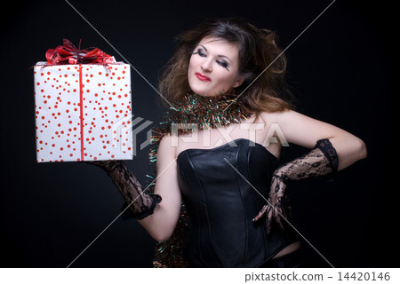 Closeup portrait of girl with red lips, tinsel and present on bl Closeup portrait of girl with red lips, tinsel and present on bl 14420146