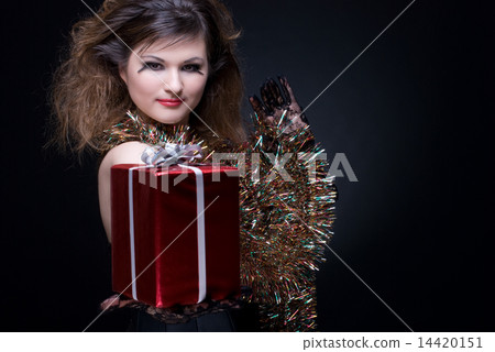 Closeup portrait of girl with red lips, tinsel and present on bl Closeup portrait of girl with red lips, tinsel and present on bl 14420151