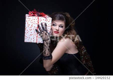 Closeup portrait of girl with red lips, tinsel and present on bl Closeup portrait of girl with red lips, tinsel and present on bl 14420152