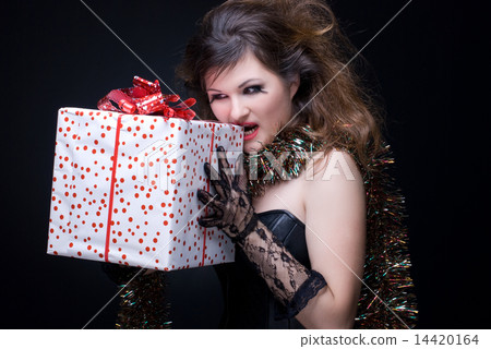 Closeup portrait of girl with red lips, tinsel and present on bl Closeup portrait of girl with red lips, tinsel and present on bl 14420164