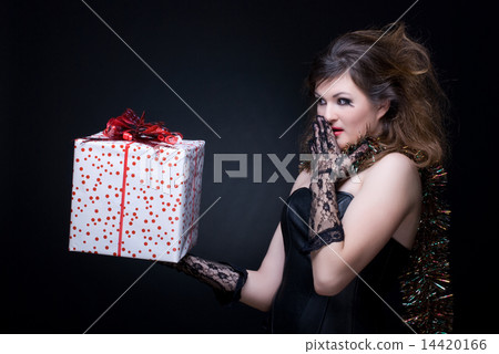 Closeup portrait of girl with red lips, tinsel and present on bl 14420166