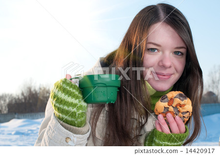 Girl on winter picnic with cup of tee and cookies Girl on winter picnic with cup of tee and cookies 14420917
