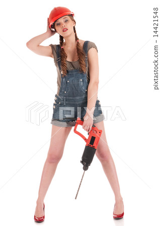 Young playful woman in jeans coverall holding perforator drill Young playful woman in jeans coverall holding perforator drill 14421548