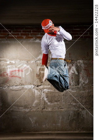 Hip hop boy dancing in modern style over grey brick wall 14422228
