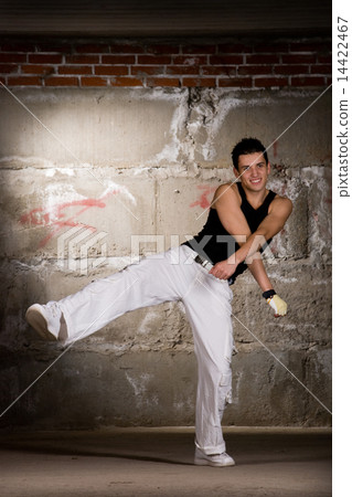 Hip hop boy dancing in modern style over grey brick wall Hip hop boy dancing in modern style over grey brick wall 14422467