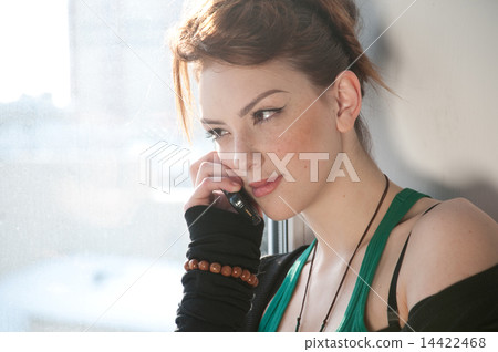 Beautiful young woman with cell phone on window. Beautiful young woman with cell phone on window. 14422468