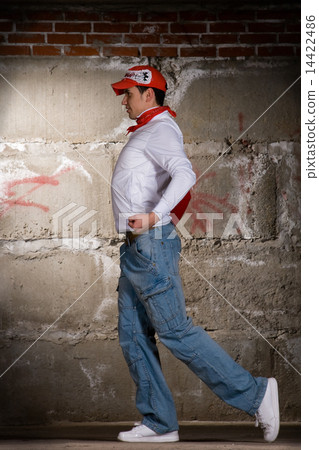 Hip hop boy dancing in modern style over grey brick wall 14422486
