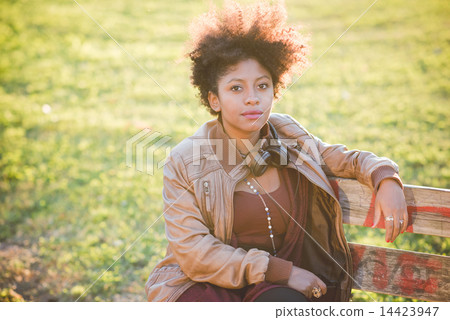 beautiful black curly hair african woman listening music with he 14423947