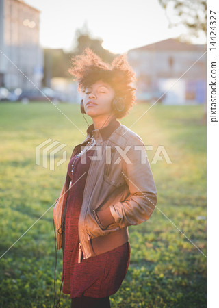 beautiful black curly hair african woman listening music with he 14424327