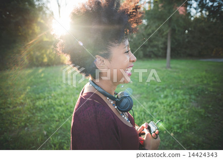 beautiful black curly hair african woman listening music with he 14424343