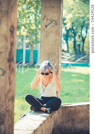 young beautiful short blue hair hipster woman with headphones mu 14424526