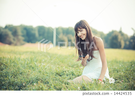beautiful young woman with white dress listening music 14424535