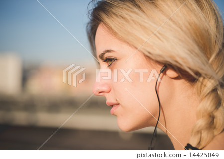 young beautiful blonde woman outdoor listening music young beautiful blonde woman outdoor listening music 14425049