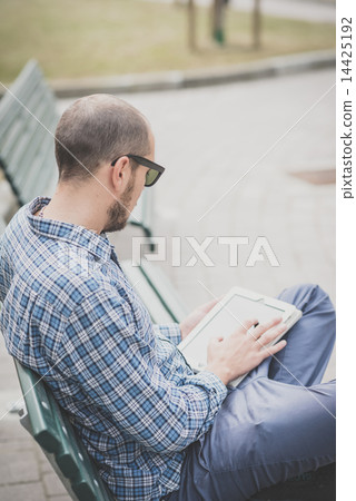 handsome hipster casual multitasking modern man using tablet 14425192