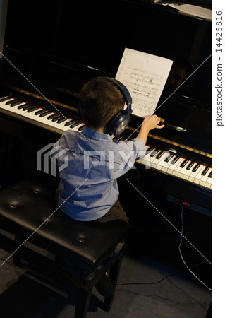 High angle view of a little boy learning piano 14425816