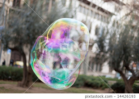 Single iridescent soap bubble floating through air 14426193