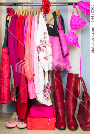 Dressing closet with red and pink clothes  14458506